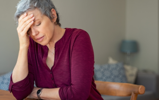 Frau mit Hand vor Gesicht